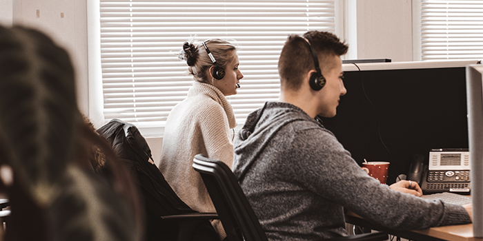 Bild von zwei TeleTeam Mitarbeitern bei der Arbeit.